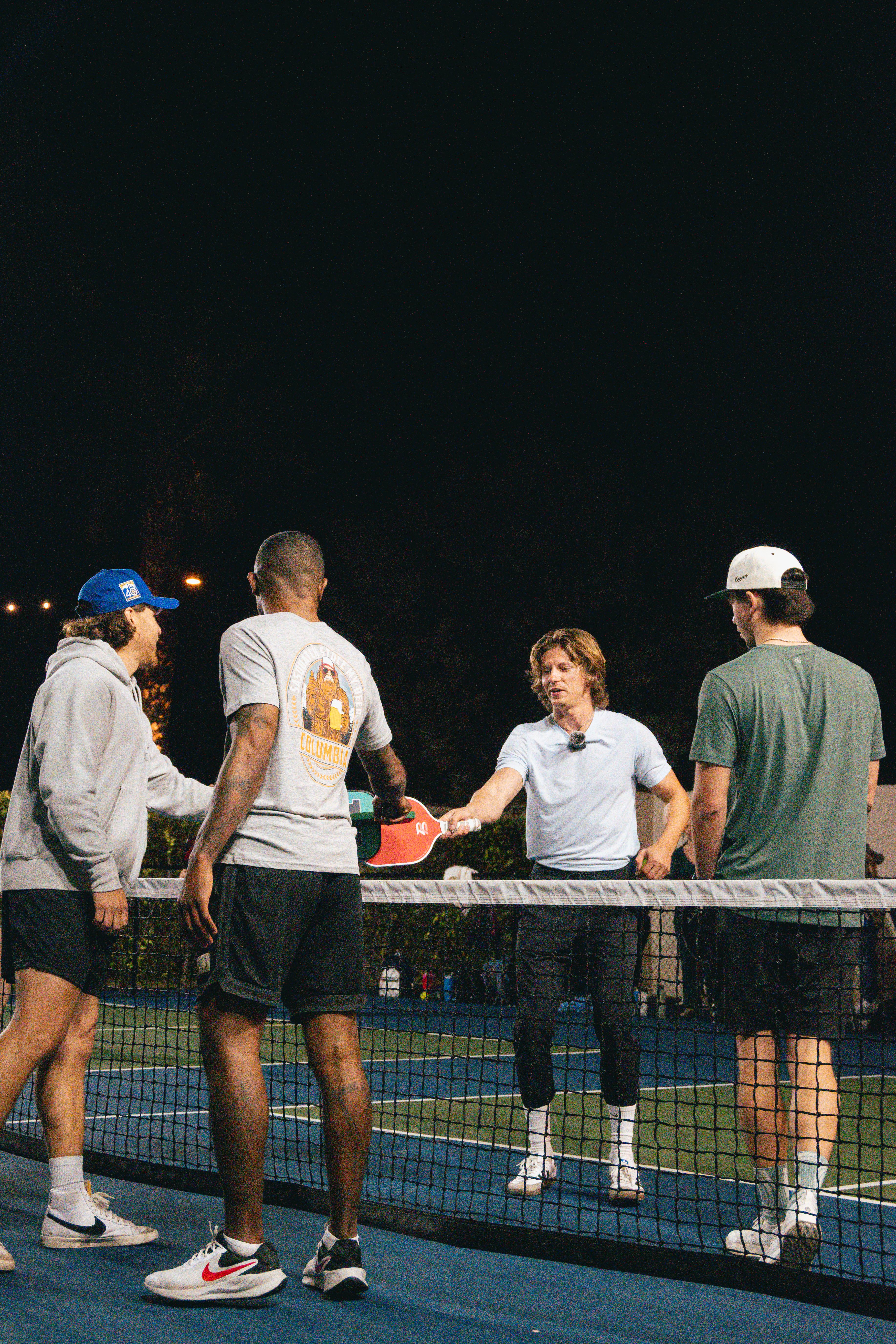 A pickleball paddle and yellow ball on a blue court corner, symbolizing sport and activity.