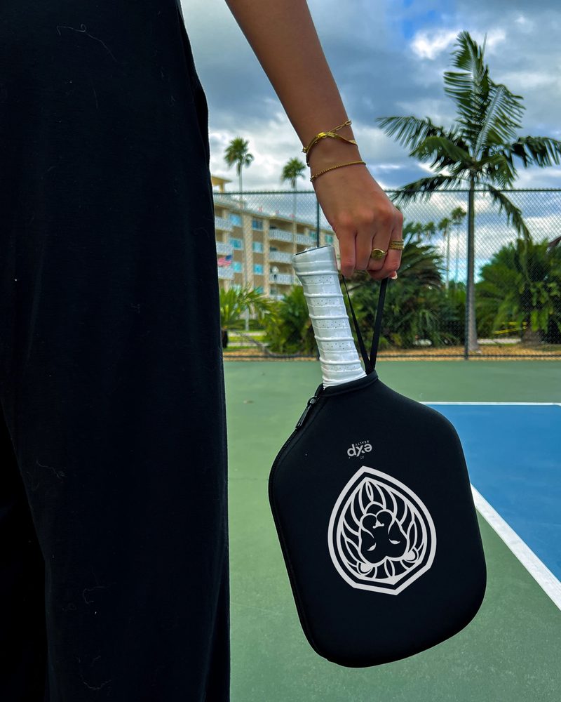 Vibrant checkered paddles and balls create a lively sports theme on green court background.